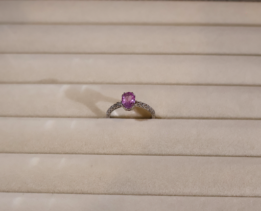 White gold Ring with a pink sapphire gemstone on a beige background