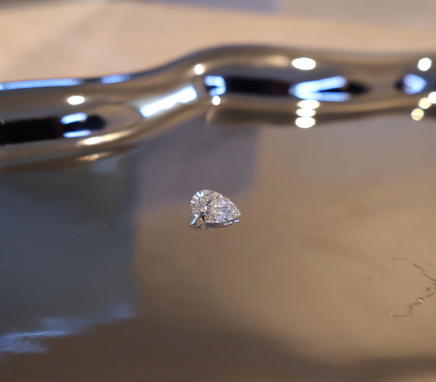 Pear-shaped diamond on a reflective surface